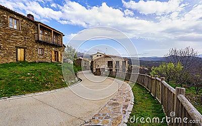 Old town street with curved street and wooden fence next to the garden. La Hiruela Madrid Stock Photo