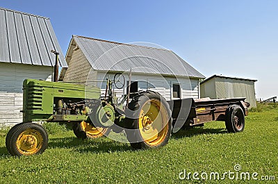 Old tractor pulling a rusty manure spreader Editorial Stock Photo