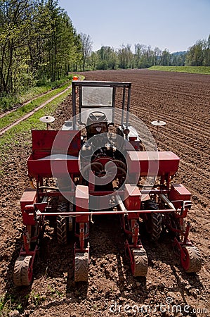 Old tractor with sower parked on worked field upside view Stock Photo