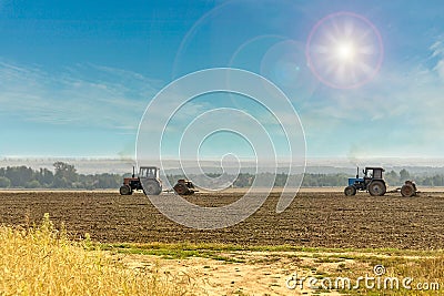 Old tractors with seeders on beautiful sunny agricultural landscape. Stock Photo