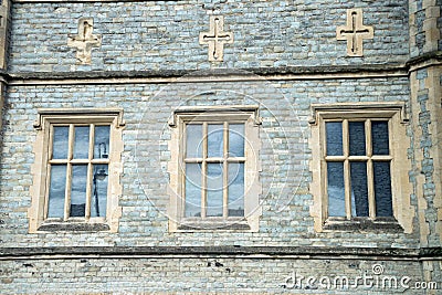 Old traditional English Architecture, three windows and crosses above Stock Photo