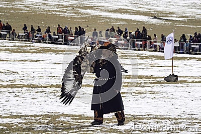 Old traditional kazakh eagle hunter harshly handled with his gol Editorial Stock Photo