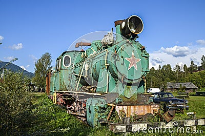 Old train locomotive green color on network of narrow-gauge railway in Carpathian village Kolochava, Ukraine Editorial Stock Photo