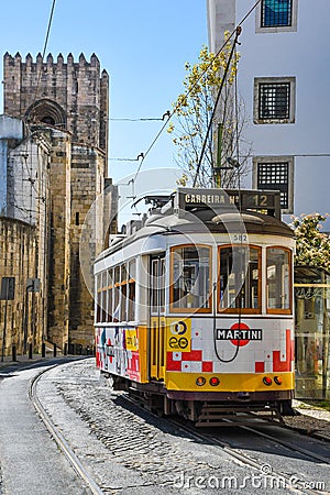 Old tram going through narrow streets in Lisbon Editorial Stock Photo