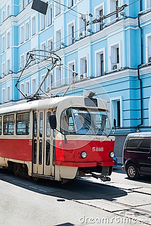 An old tram rides along a street with a blue house Editorial Stock Photo
