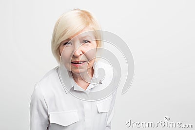 Old and tricky woman is very attentive to details. She is trying to check everything here. This grandma is very Stock Photo