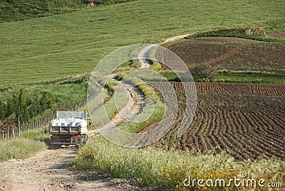 Old Truck Crosses Winding Dirt Road In Rural Area Stock Photo