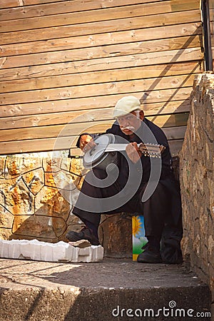 Old Turkish street musician plays the baglama Editorial Stock Photo