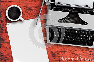 Old typewriter, cup of steaming hot coffee and stack of blank writing paper on table Stock Photo