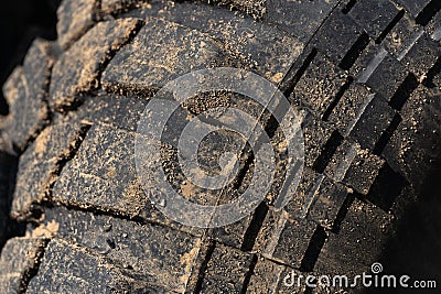 Old used extreme terrain tire with worn wear-resistant tread. Close-up of black muddy off-road tire Stock Photo