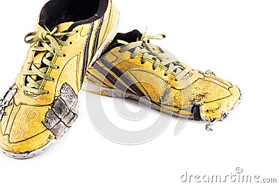 Old used yellow worn out futsal sports shoes on white background soccer sportware object isolated Stock Photo