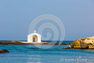 Old venetian lighthouse at harbor in Crete, Greece. Small cretan village Kavros. Stock Photo