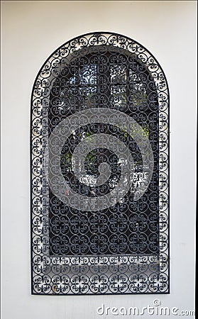 Old Venetian window with black iron grid Stock Photo