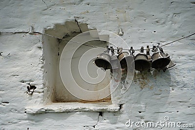 Old vintage bells hanging on a white wall temple in India Stock Photo