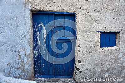 Old vintage blue wooden door with rustic stone wall Stock Photo