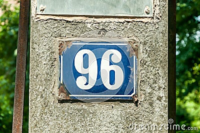 Old vintage house address metal plate number 96 ninety six on the plaster facade of abandoned home exterior wall on the street s Stock Photo