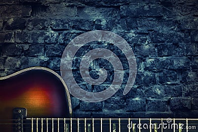 Old vintage jazz guitar on a brick wall background. Copy space. Background for concerts, festivals, music schools. Art Stock Photo