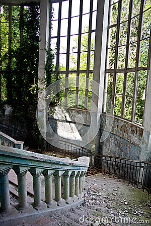 Old vintage marble spiral staircase at abandoned overgrown mansion Stock Photo