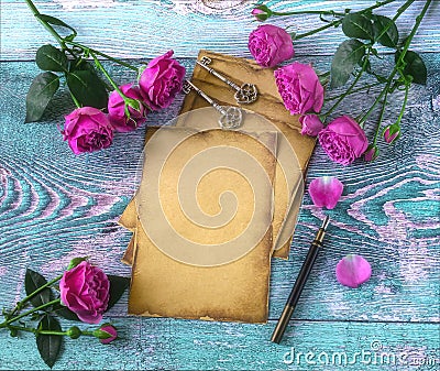 Old vintage paper, pen with quill, vintage keys, pink peony rose flowers on blue background. Love letter Stock Photo