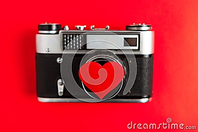 Old vintage photo camera with red heart on it. red background.for decor and design. valentines greeting card. Stock Photo