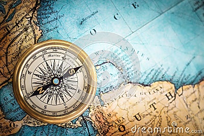 Old vintage retro compass on ancient map background. Stock Photo