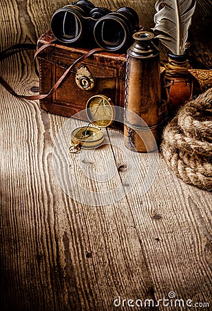 Old vintage retro compass, binoculars and spyglass on wooden tab Stock Photo