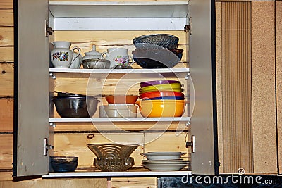 Old vintage tableware in a rustic Cabinet. The concept of simplicity, asceticism and poverty. Stock Photo