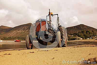Old vintage tractor on Trefor beach in Wales. Stock Photo