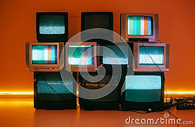 Old vintage tvs on a floor in a room with colored neon light Stock Photo