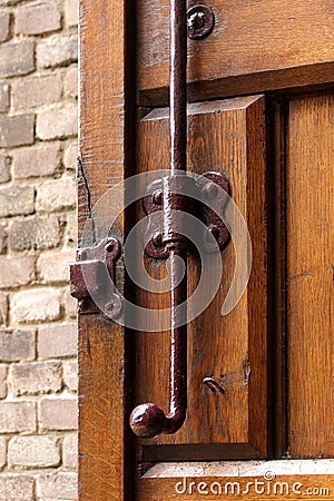 Old vintage wood door lock lock rusty brown brick wall forged wooden gate valve latch bolt catch Stock Photo