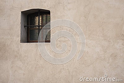 Old wall with with window opening with an iron grille Stock Photo