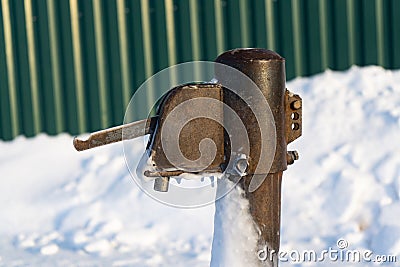 Old water column in the winter in the snow. Stock Photo