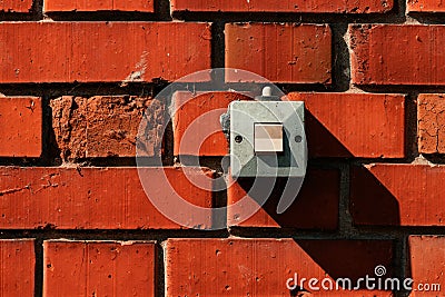 Old waterproof electricity switch mounted on house outer brick wall Stock Photo