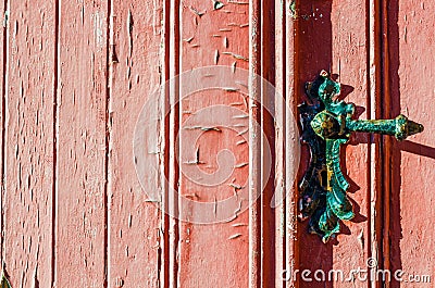 old weather-beaten red door with old vintage door knob, surface with chapped textured paint Stock Photo