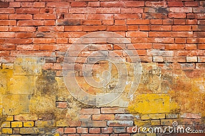 Old and weathered grungy yellow and red brick wall as seamless pattern texture background Stock Photo