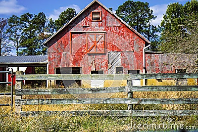 Old weathered Red Barn with Split-rail Fence in forefront Stock Photo