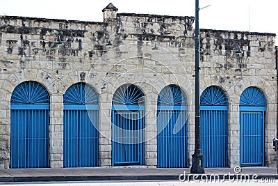 Closeup of old weathered stone building with bright blue iron gates and doorways, Austin, Texas, 2018 Editorial Stock Photo