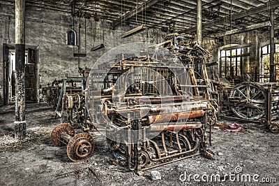 Old weaving looms and spinning machinery at an abandoned textile factory Stock Photo