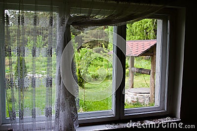 Old well seen through a rustic window Stock Photo