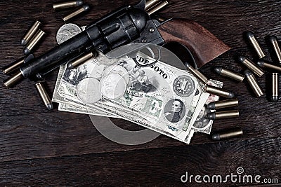 Old west Colt Peacemaker and US banknotes and silver certificates with silver dollar coins and .45 caliber revolver ammunitions Stock Photo
