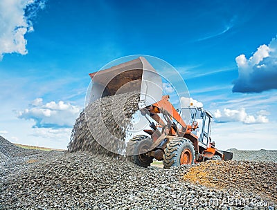 Old wheel loader excavator loadding gravel Stock Photo