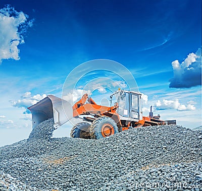 Old wheel loader excavator working with gravel Stock Photo