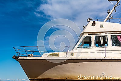 Old white boat shot sidewise against blue sky Stock Photo