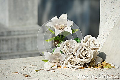 Old white fake flower on grave Stock Photo