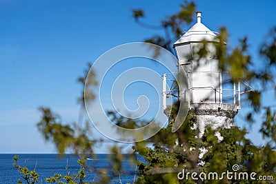 Old white lighthouse at Stenhuvud national park in Simrishamn, Sweden. Foreground blurr and selective focus Stock Photo