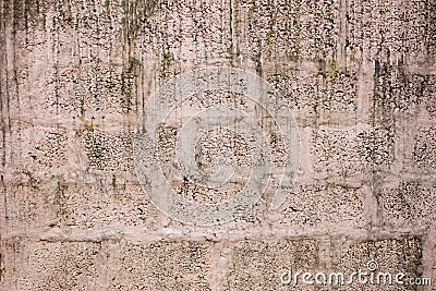 A Old white pink concrete wall of large bricks. drips of dirt and paint. rough wall surface. Stock Photo