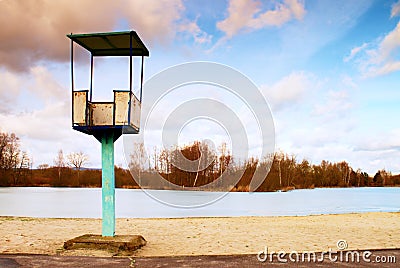 Old white and rusty metal lifeguard tower with chair on a beach. Frozen water level within witer Stock Photo