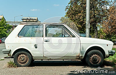 Old white rusty Yugo car made in Zastava Kragujevac parked on the street in the city Editorial Stock Photo
