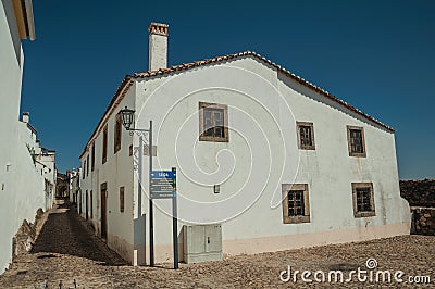 Old whitewashed house in front a cobblestone square Stock Photo