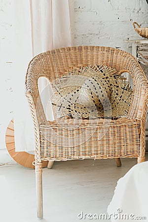 The hat rests on a wicker chair, a light interior, Summer hygge scene with hammock chair Stock Photo